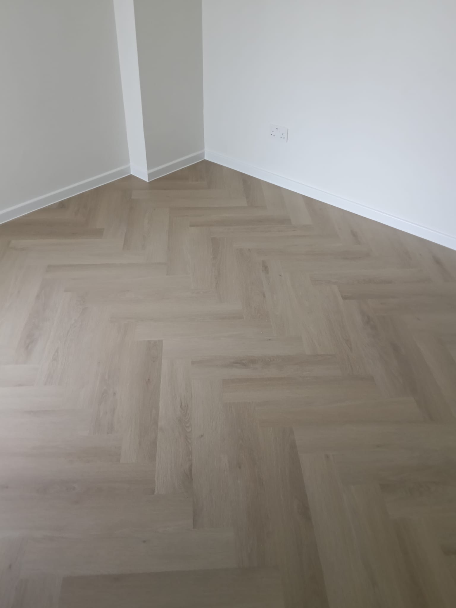 Light wood herringbone vinyl flooring installed in a Singapore room