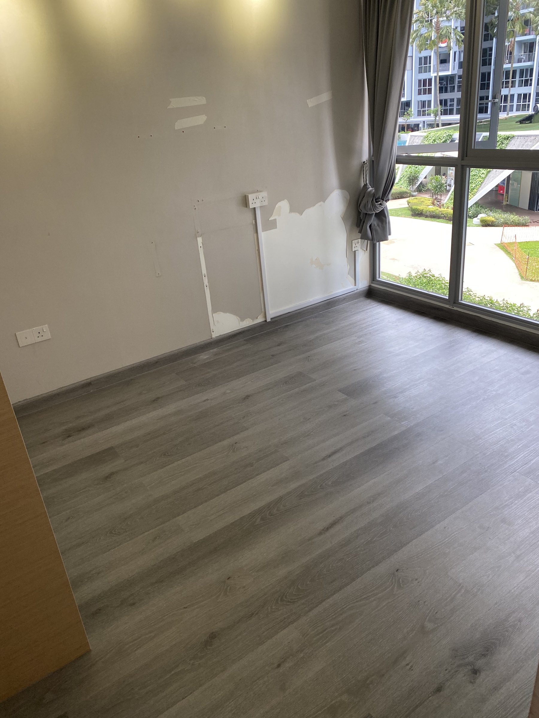 Dark grey wood-look vinyl flooring in a Singapore living area