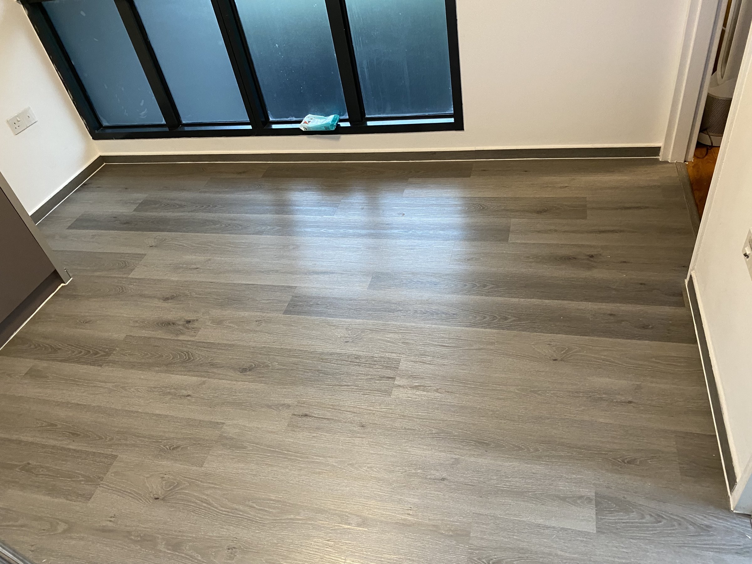 Dark grey wood-look vinyl flooring in a Singapore bedroom