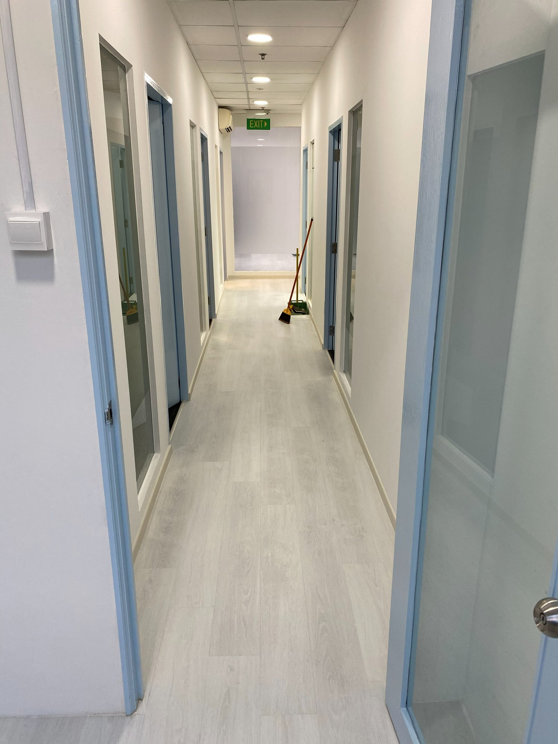 Light grey vinyl plank flooring in a Singapore commercial corridor