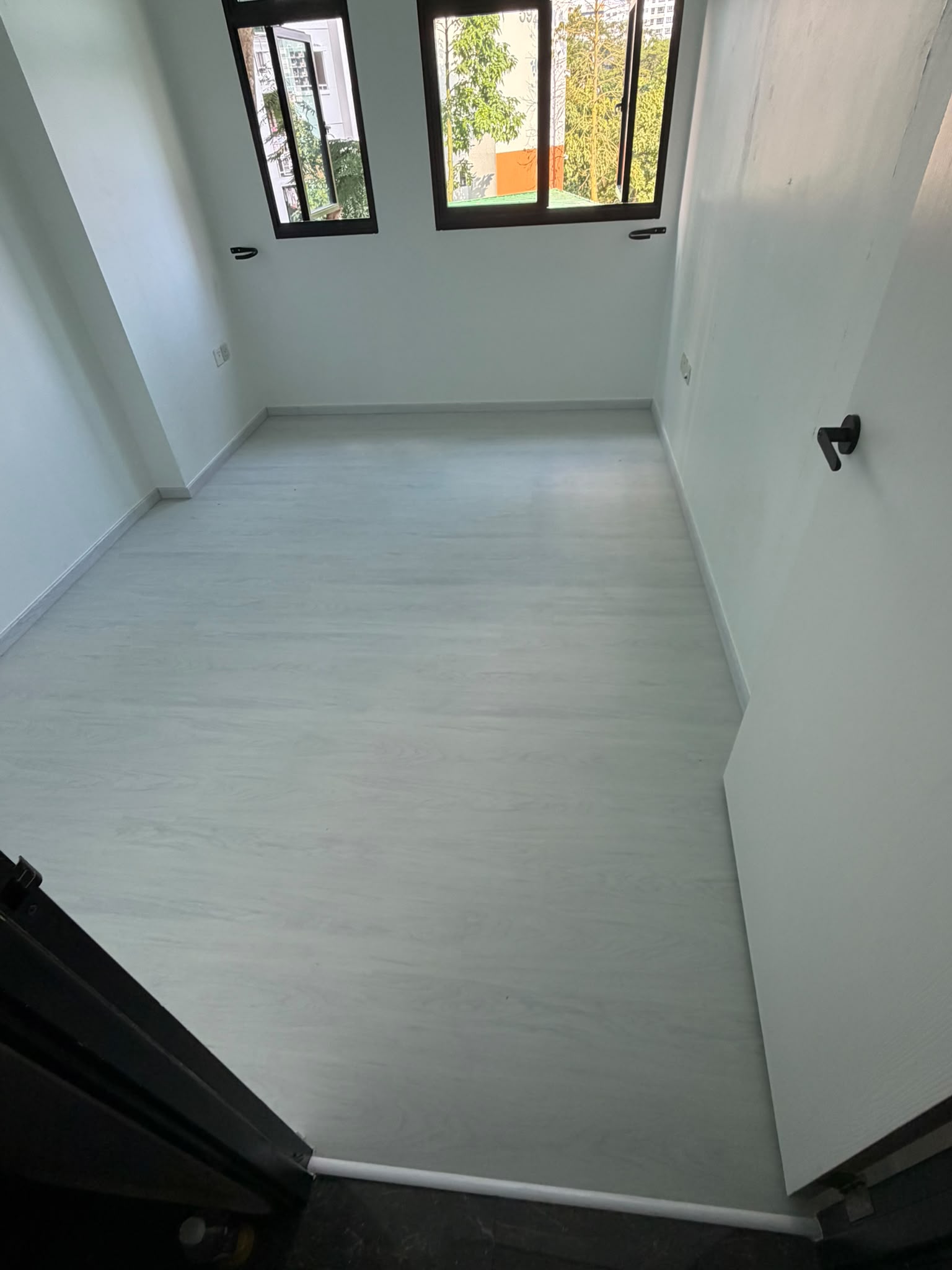White wood look vinyl flooring in a bright bedroom