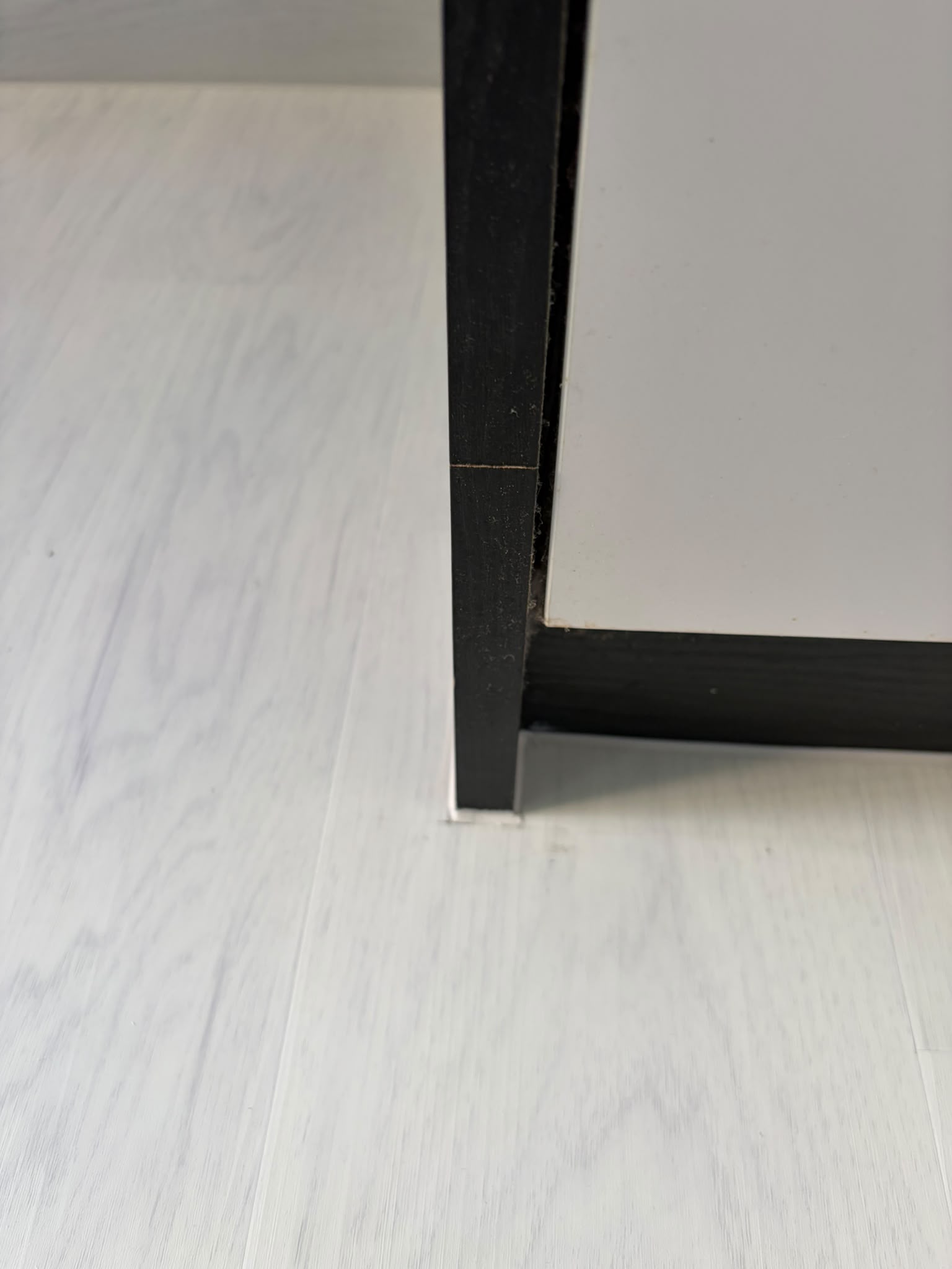 Close-up of white wood look vinyl flooring around built-in cabinetry